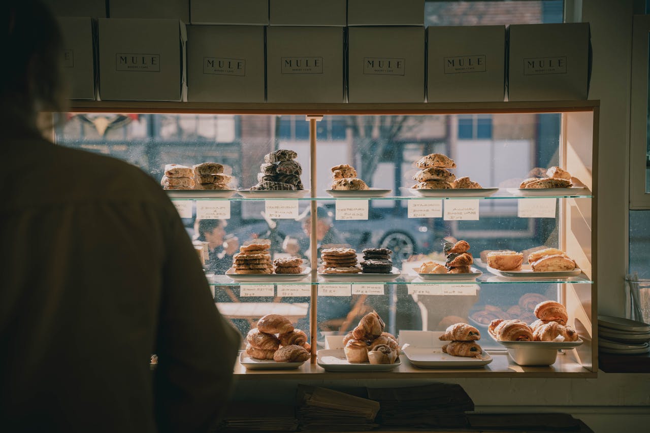 A cozy bakery scene showcasing a display case filled with various pastries and baked goods.